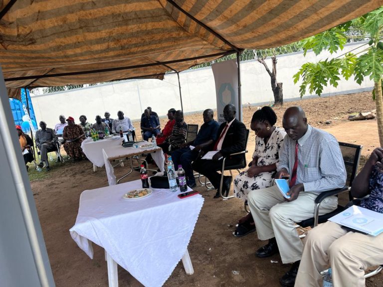 Guests seated under the canopy at the ceremony